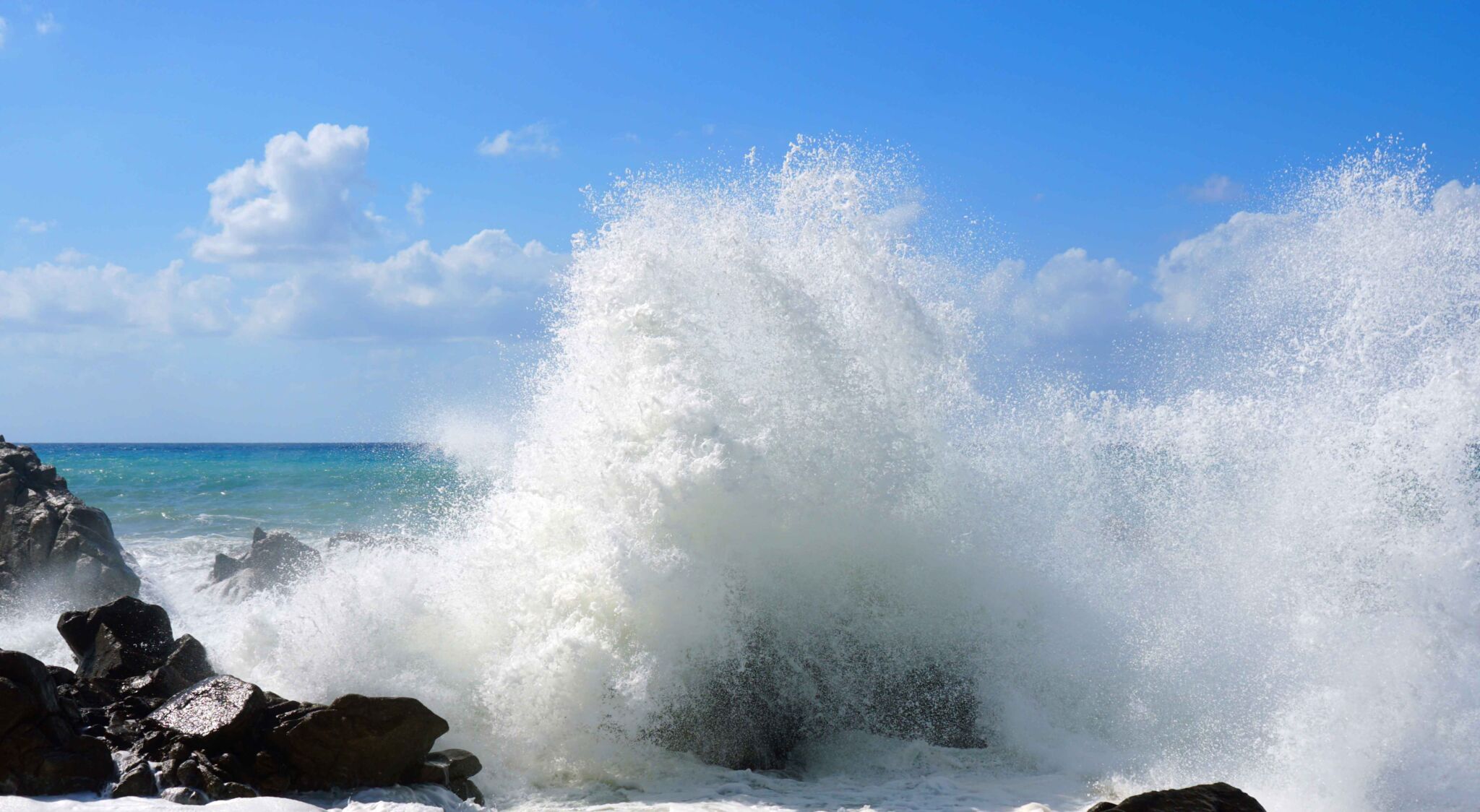 A beautiful image of strong waves crashing on the rocks on a shore