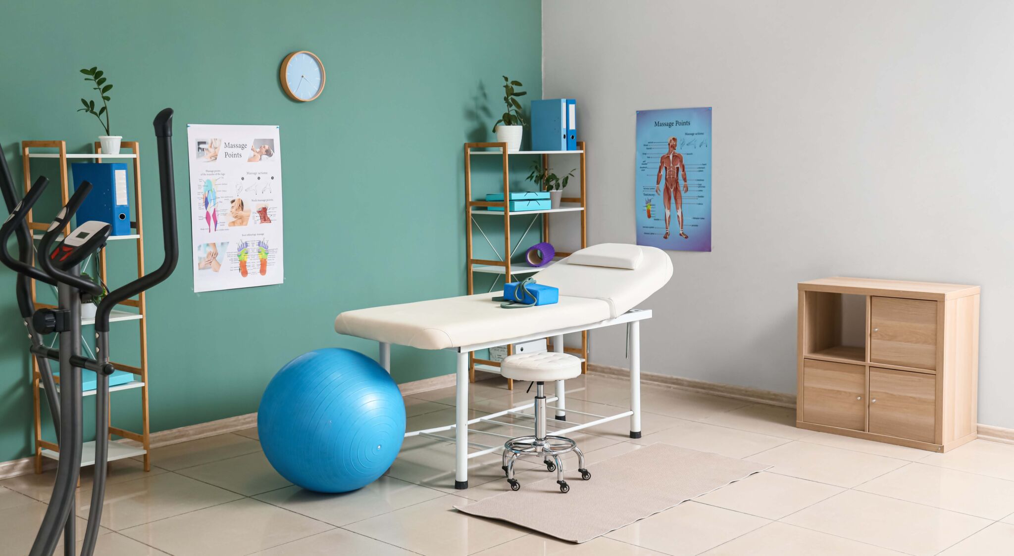 Interior of physiotherapist's office with couch, shelf units and fitball